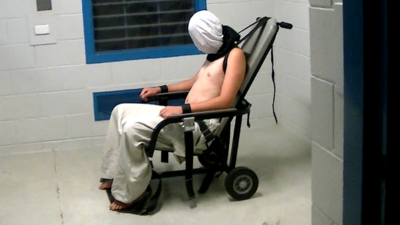 Dylan Voller is shown hooded and strapped into a chair in 2015