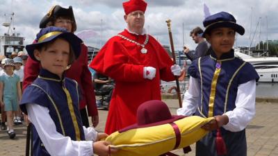 Children carry replica of Wolsey's red hat