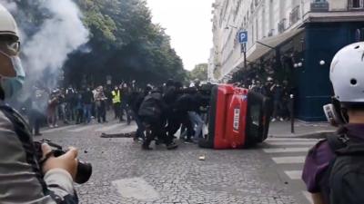 Protesters overturn car at rally for health workers in Paris