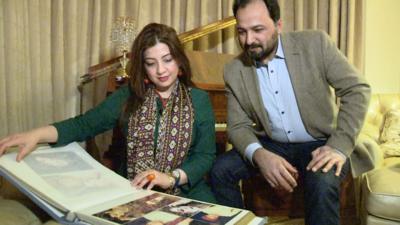 Hina and Kam looking at their wedding photo album.