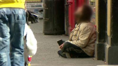 Person begging on street - identity obscured