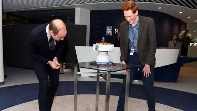 Prince William (L), Duke of Cambridge is presented with a cake by Aerospace engineer and Bake Off runner-up Aero Andrew Smyth during a visit to the Rolls Royce technology centre in Derby, central England on November 30, 2016