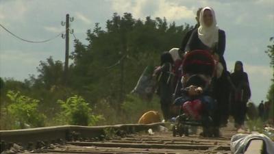 Migrants walking on railway line