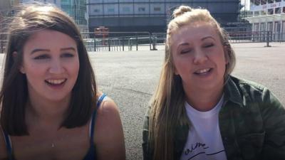 Two girls sitting down outside the Principality Stadium