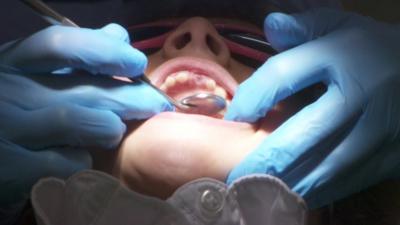 Mouth being inspected by dentist