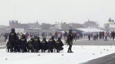 Police on airport runway looking at protesters