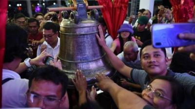 Crowds reach to touch the Balangiga bell