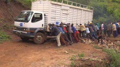 People pushing lorry