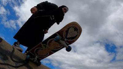 Girl going to use skateboard on ramp