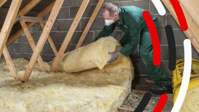 Worker insulating a roof of a building