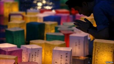 Man prays after releasing a paper lantern