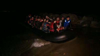 A boat carrying refugees including a five-day-old baby arrives on a beach in Kos