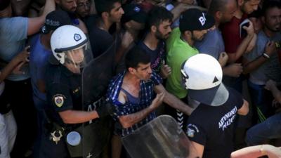 Migrants clash with riot police