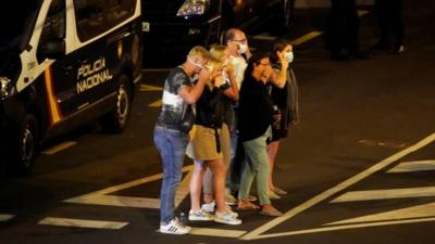 Hotel guests pose for photo wearing masks