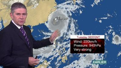 BBC Weather presenter Philip Avery stands in front of a satellite chart showing the progression of Typhoon Megi.