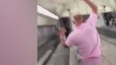 Man sliding along tube escalator