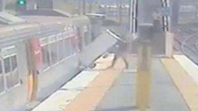 Man placing fridge on train