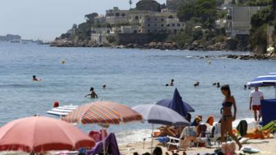 People enjoy a day out at the beach near the villa of the Saudi king in Vallauris Golfe-Juan, southeastern France