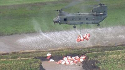 An RAF Chinook helicopter drops sandbags in Croston