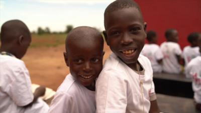 Two children smiling outside the world's first 3D-printed school