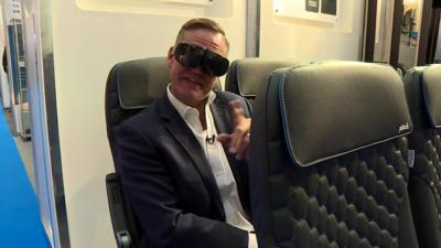 Aaron wearing VR goggles on an airline