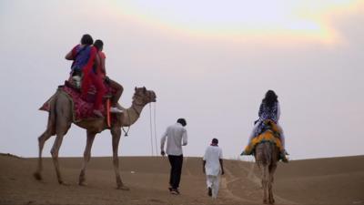 Tourists on camels in India's Thar desert