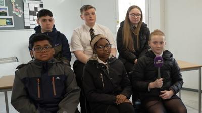 group of children looking at camera in school uniforms and coats