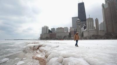 Man walks over frozen ground in Chicago. Picture by Scott Olsen