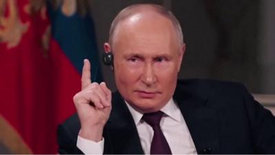 Vladimir Putin raising finger during interview with Tucker Carlson