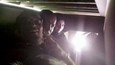 Migrants take a selfie travelling under a train