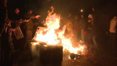 Protesters start a fire on the roadside