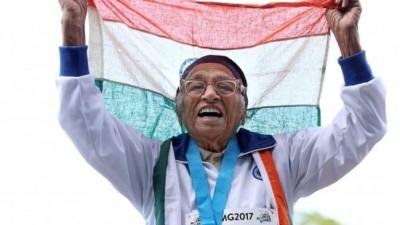 Man Kaur holds the Indian flag aloft after her victory