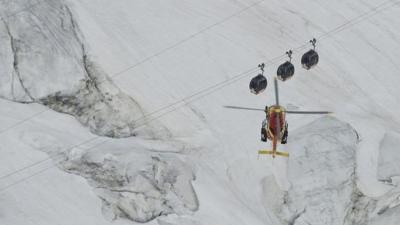 Helicopter flies near cable cars