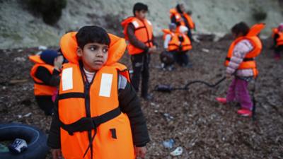 Migrant children wearing life jackets wait for a dinghy to sail off for the Greek island of Lesbos from the Turkish coastal town of Dikili