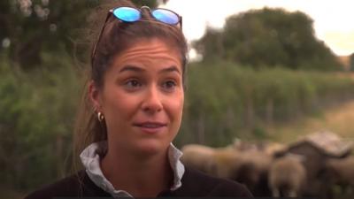 Young female farmer speaking to reporter