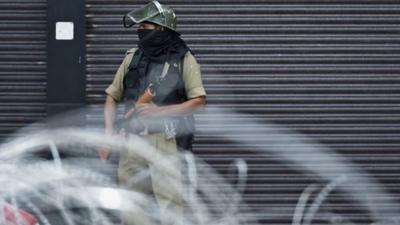 A security personnel stands guard on a street in Srinagar on August 28, 2019