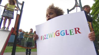 Child holding up Fizzwiggler sign
