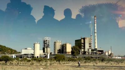 Silhouette of workers over SA platinum mine