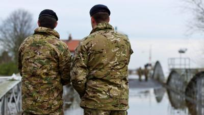 Two soldiers with their backs to the camera