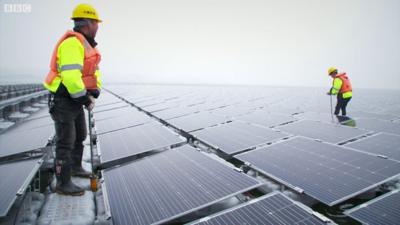 Two engineers working on floating solar panels