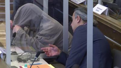 A defendant hides in face on trial in Germany