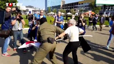 Nina Bahinskaya, 73, is bundled into a van by a masked officer