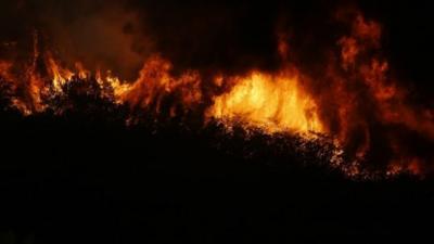 LOWER LAKE, CA - AUGUST 11: Fire is seen burning on a ridge along Morgan Valley Road during the Jerusalem Fire on August 11, 2015 near Lower Lake, California