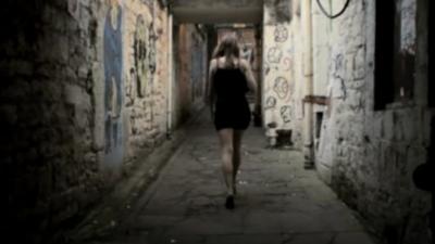 Woman waling down alley way