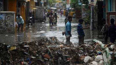 People stand in a flooded street in Chennai. Picture by Arun Sankar/AFP