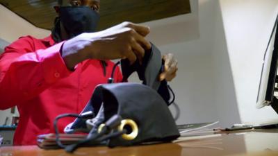 A man folding a face mask for sale