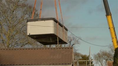 A crane removes a spa from the home of Captain Tom's daughter.