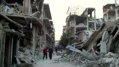 Young Syrian men surrounded by rubble in Homs, file pic from 29 Nov 2012