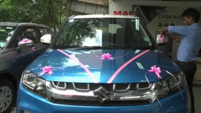 New car adorned with pink ribbons