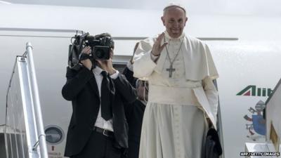 Pope Francis waves as he boards a plane prior to his departure from Mpoko International Airport in Bangui, on November 30, 2015